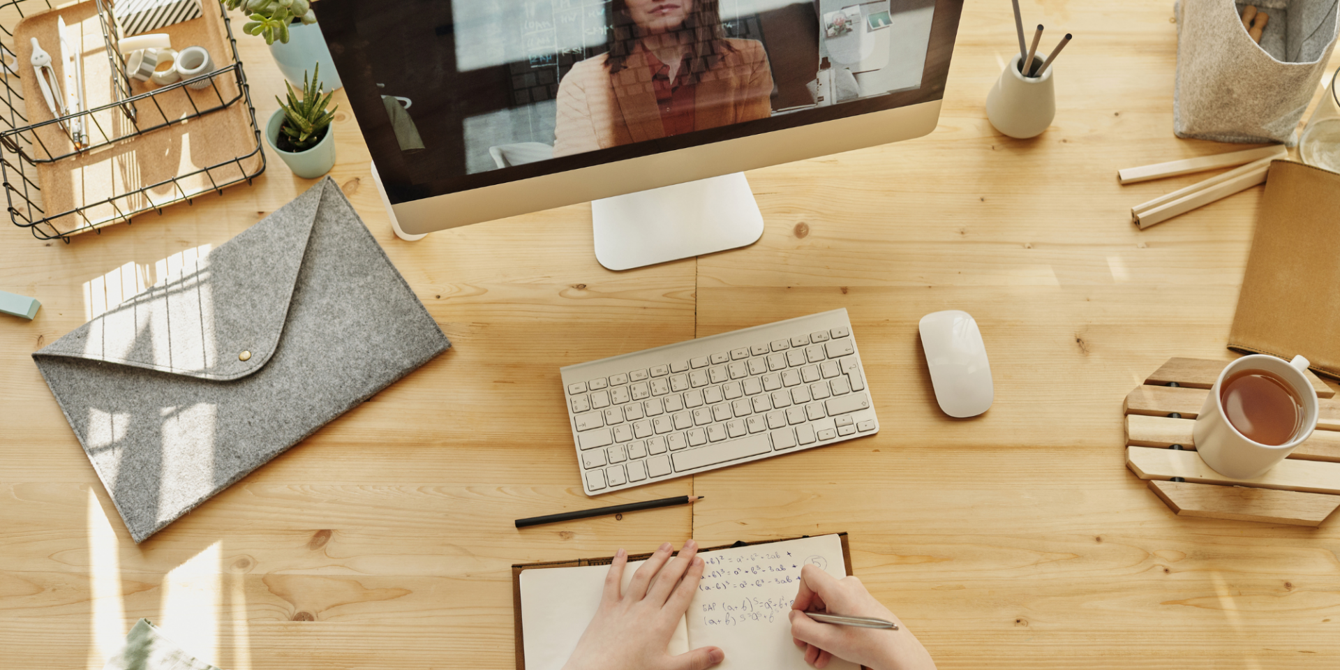 Student writing notes in front of a computer